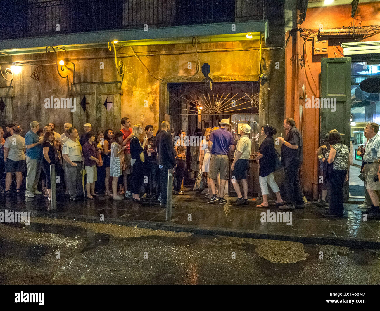 Eine nasse Nacht Line-up auf multirassische jazz-Liebhaber in St. Peter-Straße in der Stadt French Quarter New Orleans berühmten musikalischen Veranstaltungsort Preservation Hall eingeben. Stockfoto