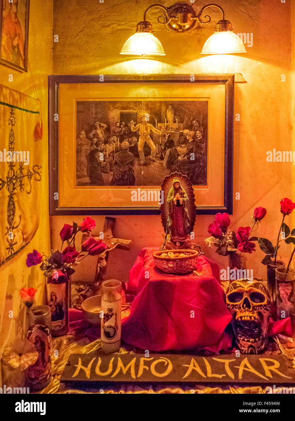 Im Voodoo Museum in New Orleans mischt sich ein Humfo Altar Christentum und Voodoo mit katholischen Heiligen, Voodoo-Geister darstellt. Hinweis: Ätzen von Voodoo-Zeremonie, Statue der Maria, künstliche Rosen und Modell Schädel. Stockfoto