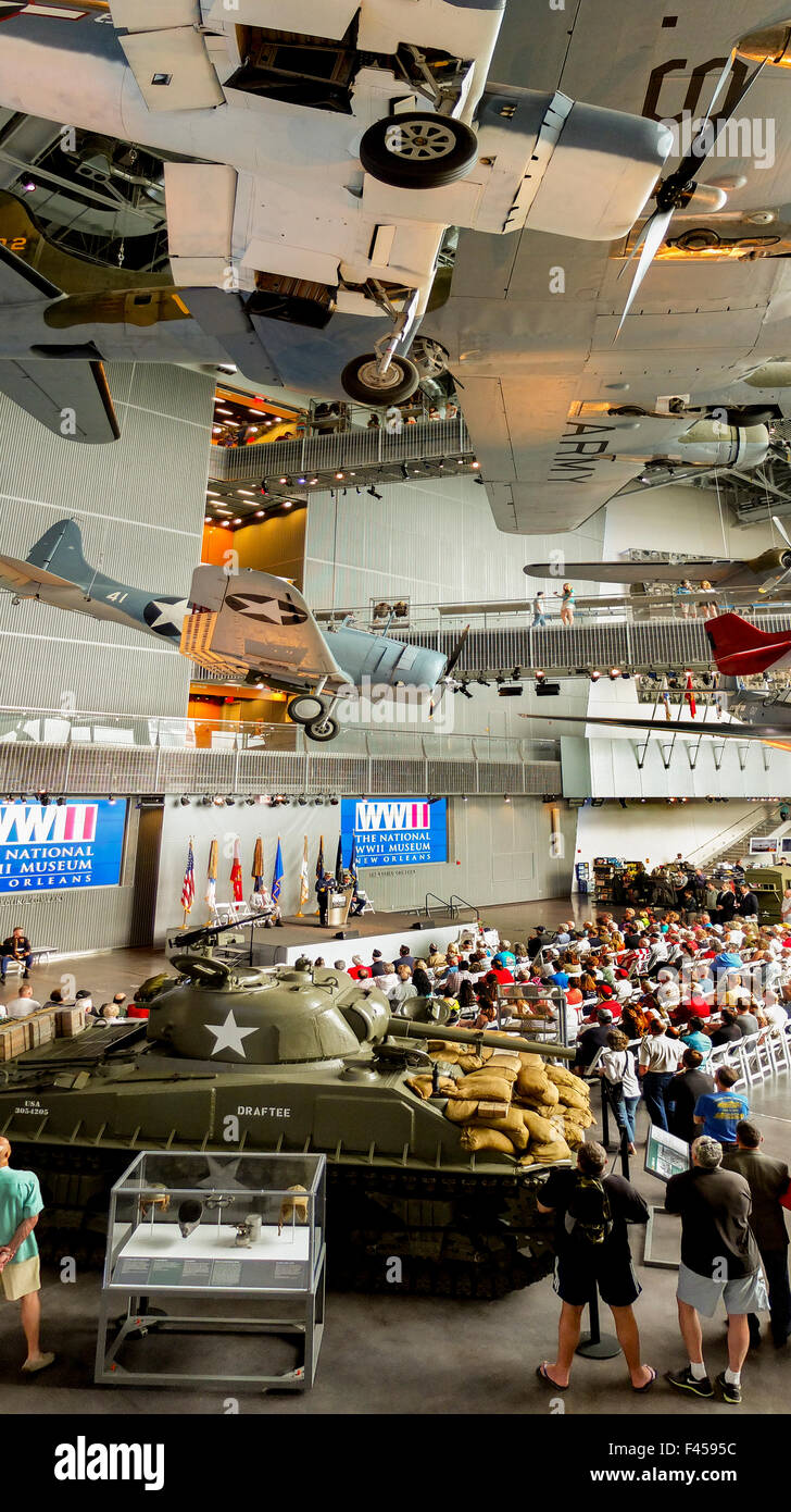 Umgeben von historischen Waffen, sammelt eine Menge für eine Einhaltung der Gedenktag an die Nation World War II Museum in New Orleans. Stockfoto