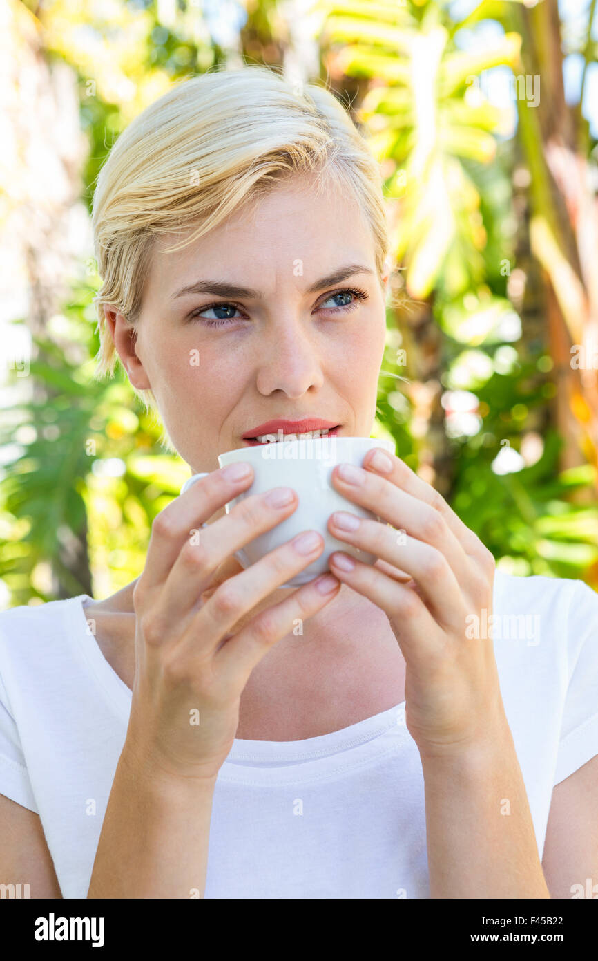 Attraktive blonde Frau heißen Getränk trinken Stockfoto