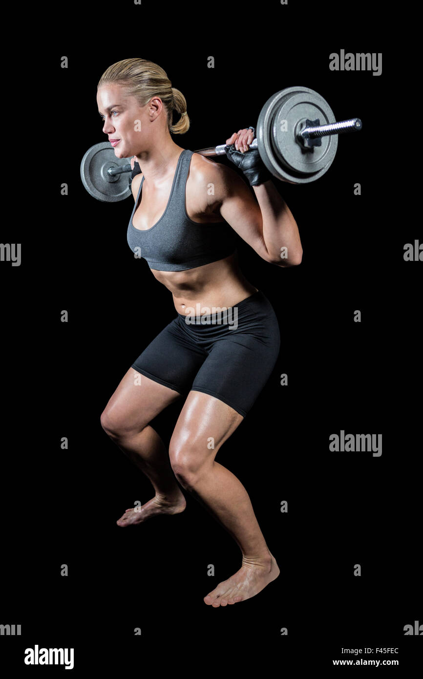 Muskulöse Frau heben schwere Langhantel Stockfoto