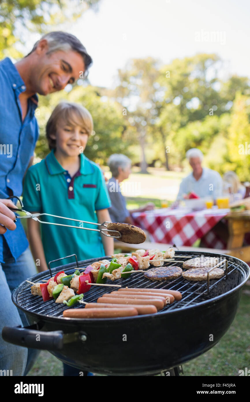 Glücklicher Vater Grill mit seinem Sohn zu tun Stockfoto