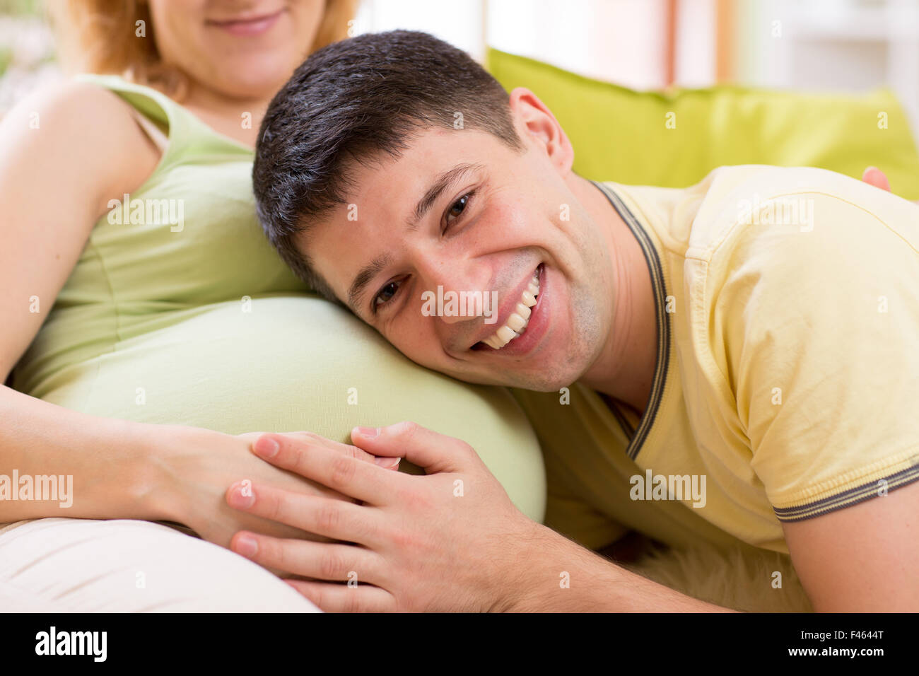 Zukünftige Vater Bauch seiner schwangeren Frau anhören Stockfoto