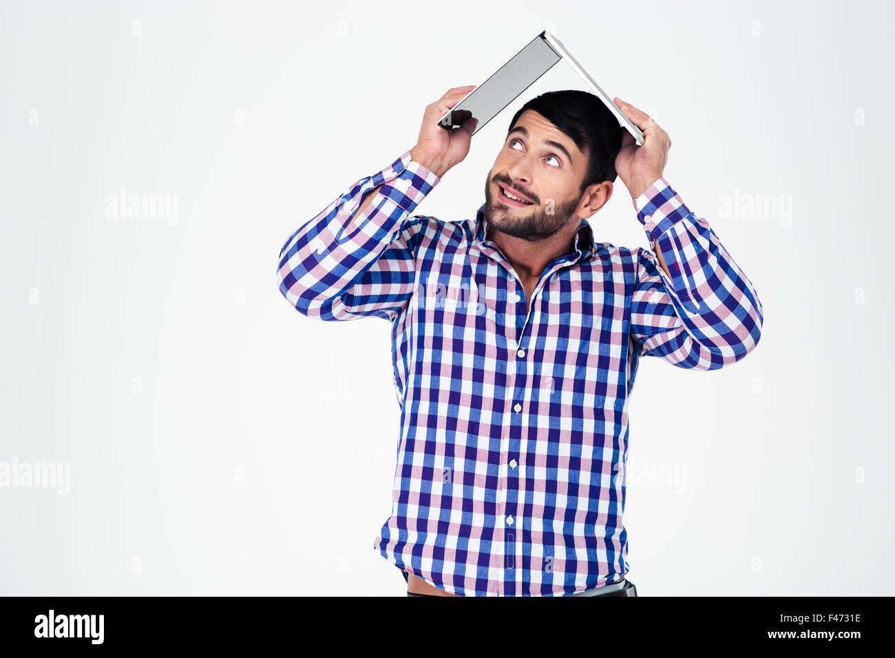 Porträt eines Mannes mit Laptop auf dem Kopf wie Dach des Hauses isoliert auf weißem Hintergrund Stockfoto
