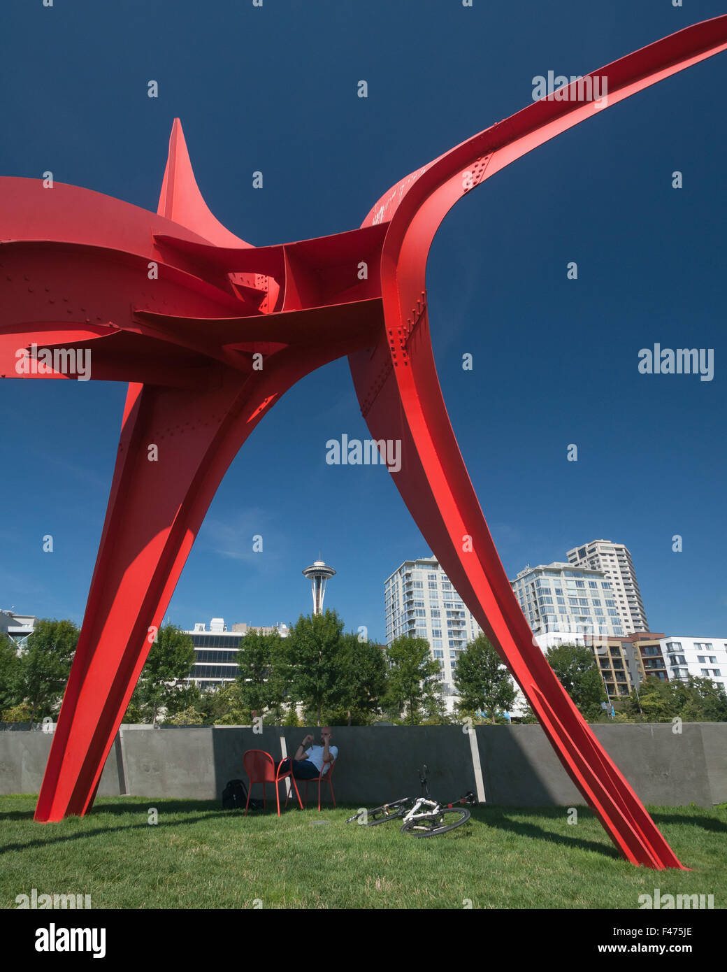 Radfahrer, die eine Pause im Schatten der Skulptur "Der Adler" Olympic Sculpture Park, Seattle, mit der Space Needle hinter Stockfoto