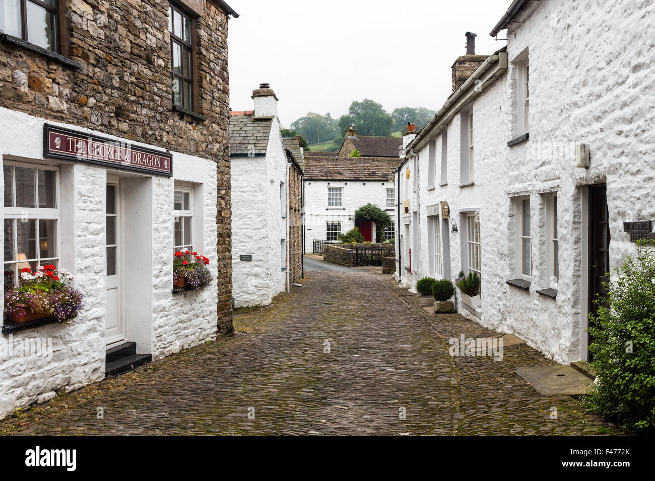 Weiß getünchten Häuschen und gepflasterten Straße im Dorf von Dent, Dentdale, Cumbria, UK Stockfoto