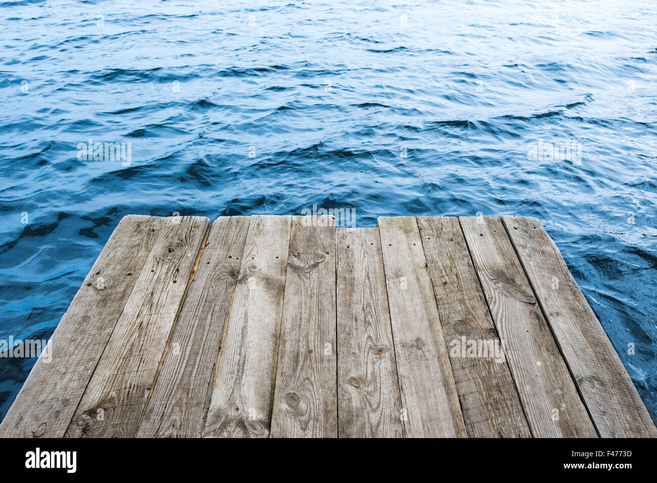 Blaues Wasser mit leeren Holzplattform Stockfoto