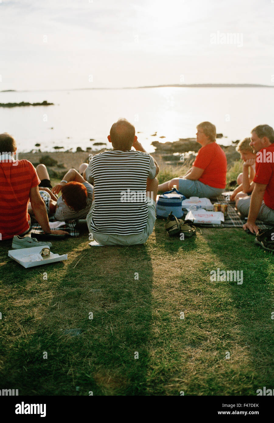 Eine große Gruppe von Menschen, die Essen Pizza im Sonnenuntergang, Schweden. Stockfoto