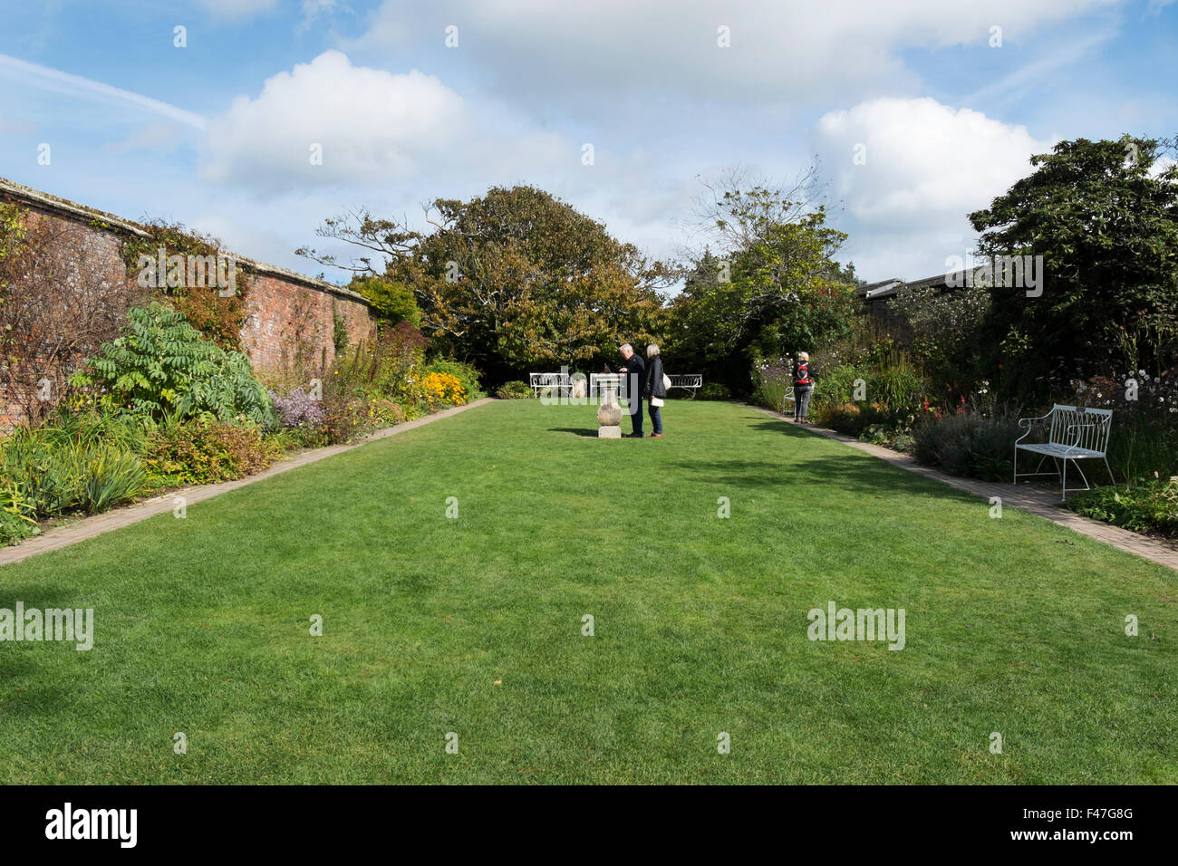 Die Menschen genießen die Sonnenuhr Garten an der Verlorenen Gärten von Heligan, Cornwall, Großbritannien Stockfoto