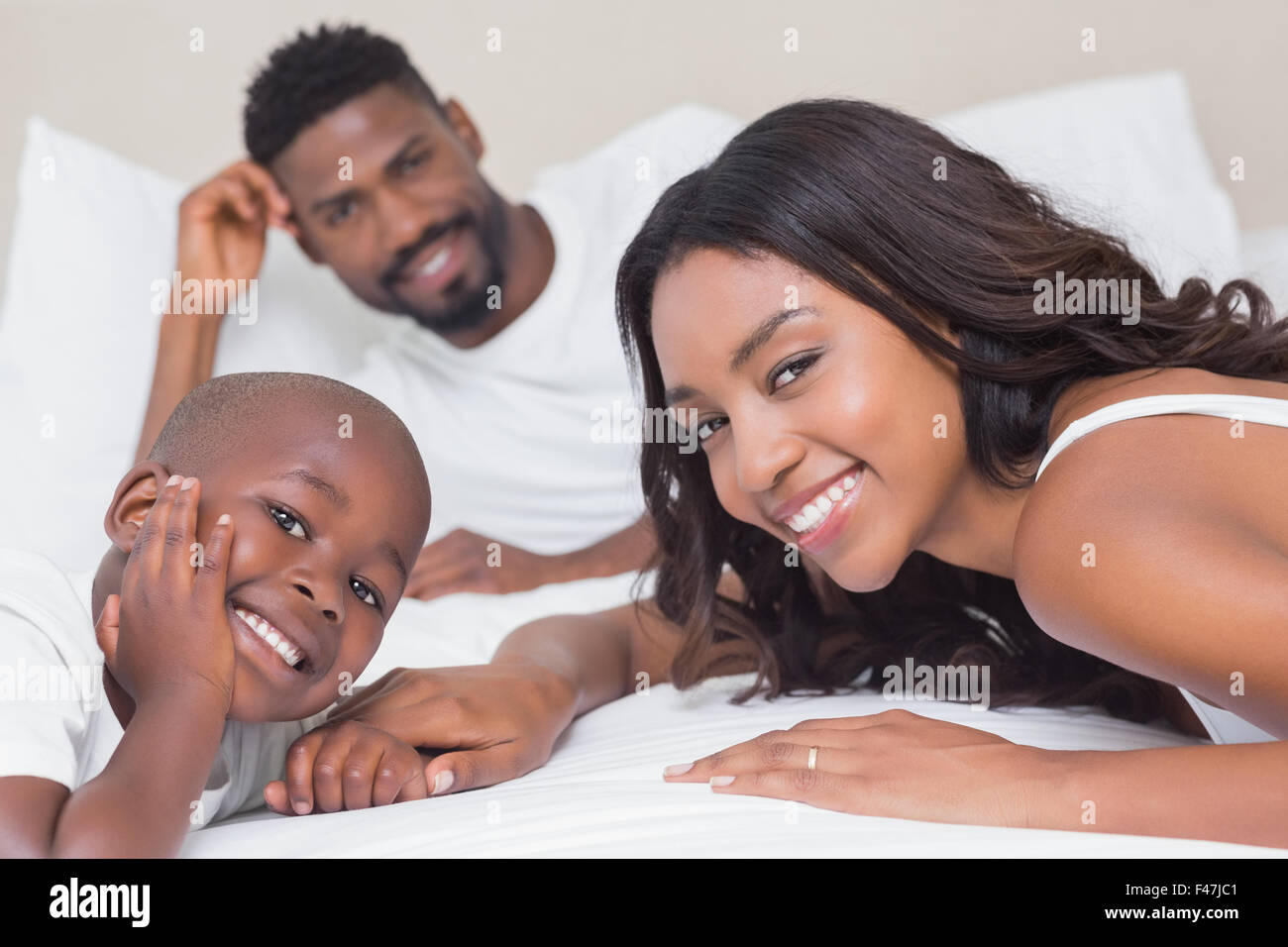 Glückliche Familie auf dem Bett Stockfoto
