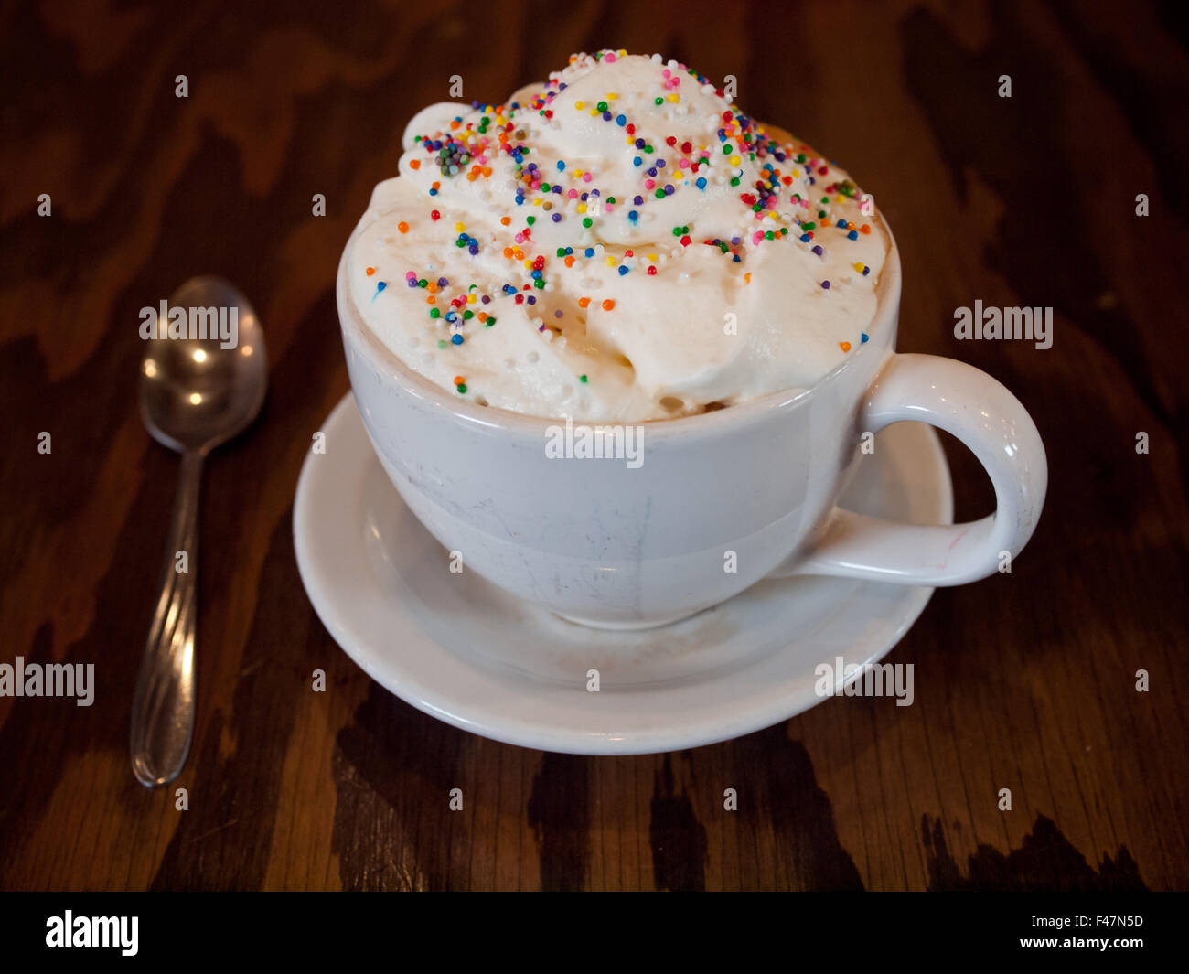 Eine heiße Geburtstag Kuchen Milchkaffee mit bunten Streuseln und Schlagsahne aus d'Lish Tish Café in Saskatoon, Saskatchewan, Kanada. Stockfoto