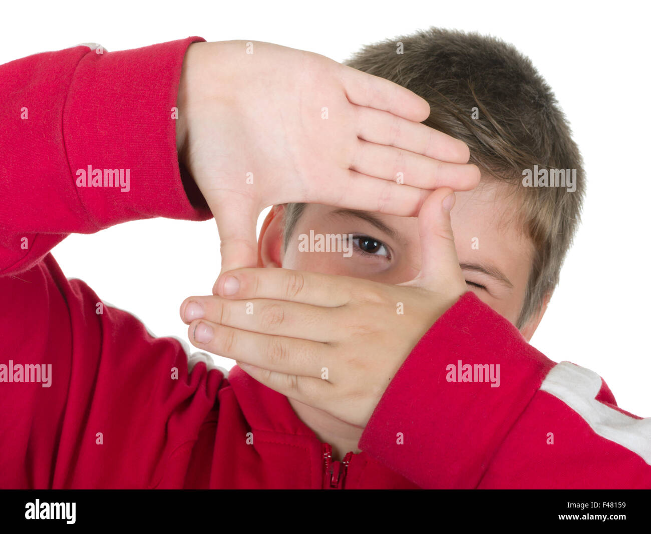 Junge blickt durch einen Rahmen aus Händen Stockfoto