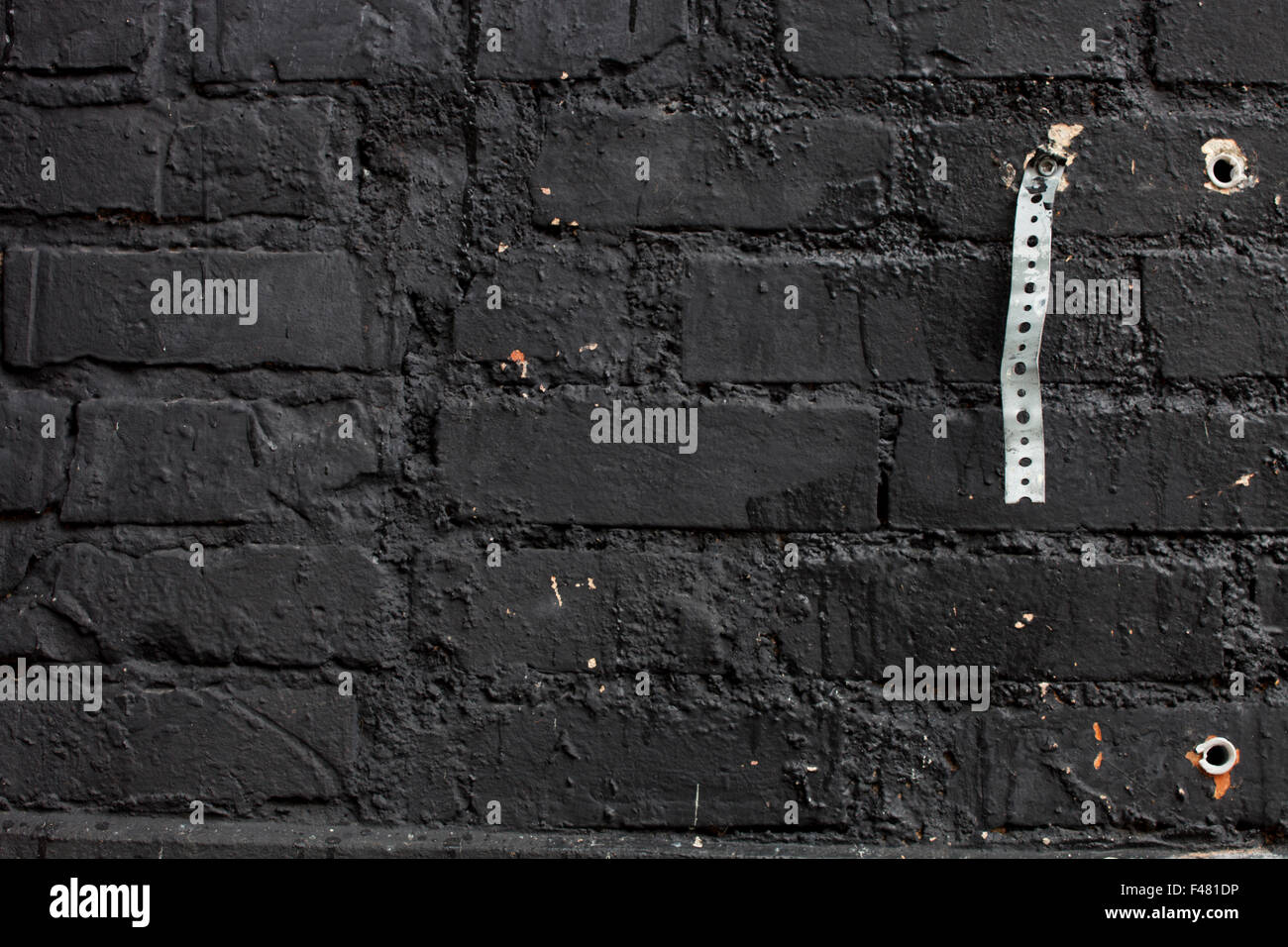 Ziegelmauer mit schwarzer Farbe bemalt. Stockfoto