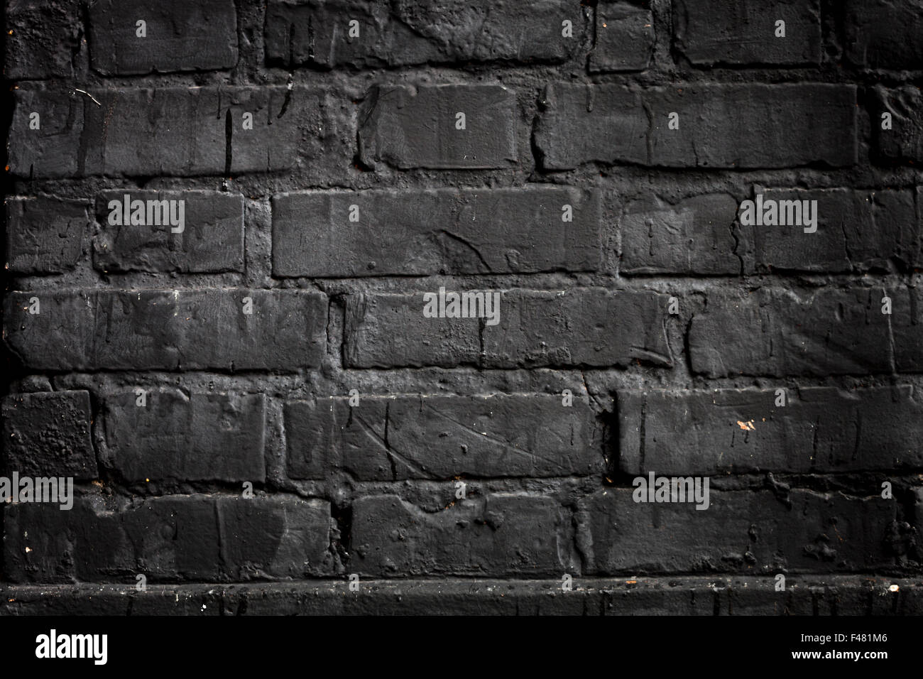 Ziegelmauer mit schwarzer Farbe bemalt. Stockfoto