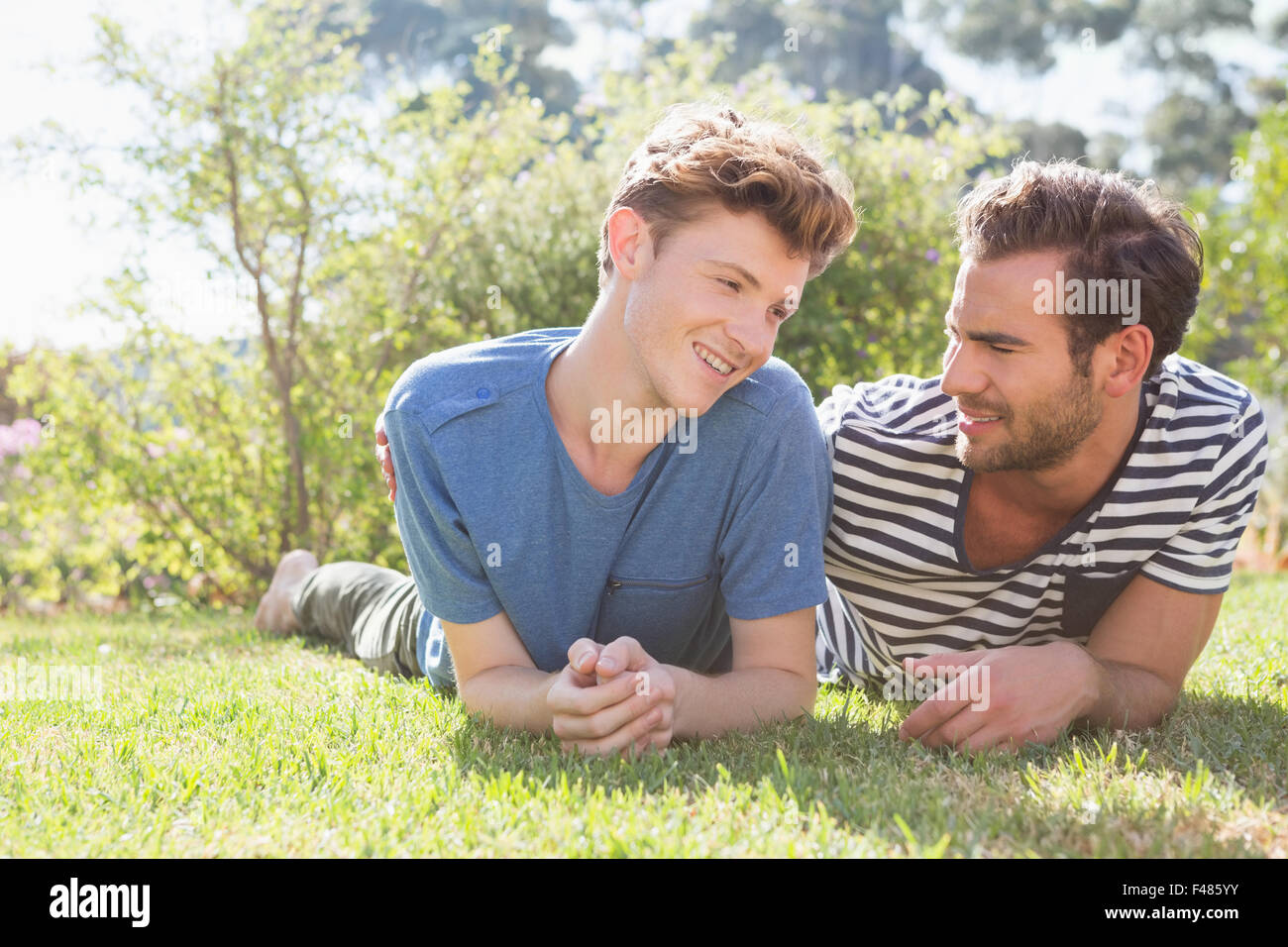 Glückliche homosexuelle Paar liegen auf dem Rasen Stockfoto
