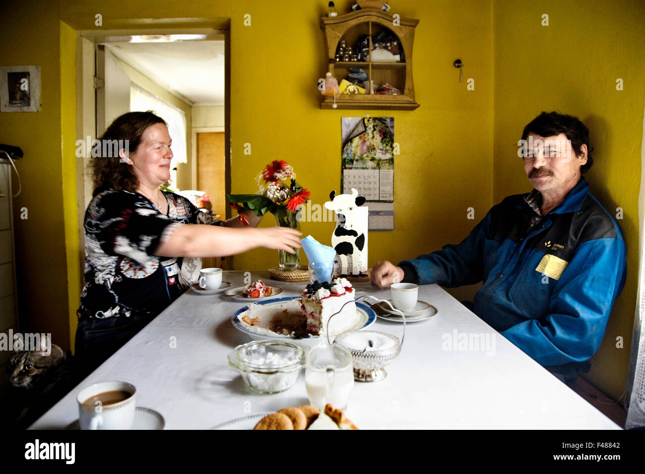 Ein paar mit Kaffee und Kuchen in ihrer Küche, Finnland. Stockfoto