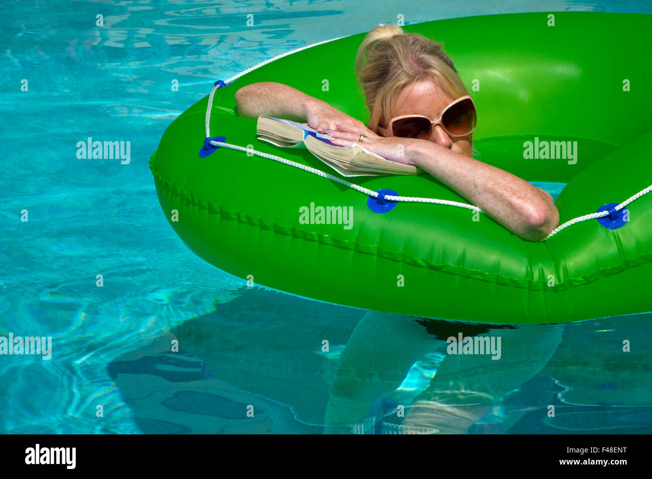 Frau im Urlaub entspannen Sie sich auf einen Gummiring in einem pool Stockfoto