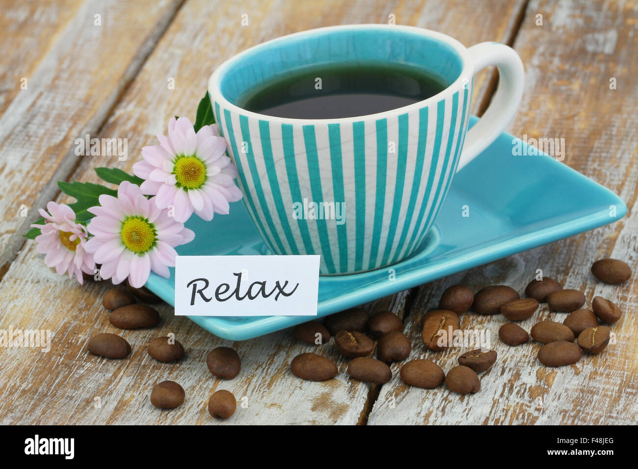 Wort mit Tasse Kaffee und rosa Gänseblümchen Blumen entspannen Stockfoto
