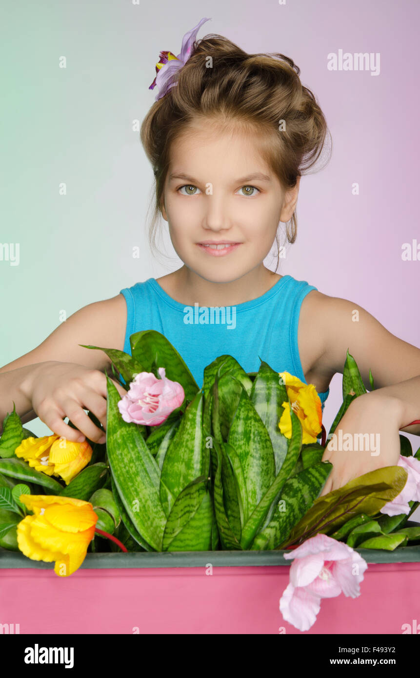 glückliches Mädchen sorgt für Blumen Stockfoto