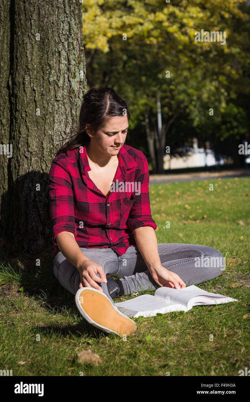 Studentinnen Schulbuch im Herbst tagsüber im freien Stockfoto