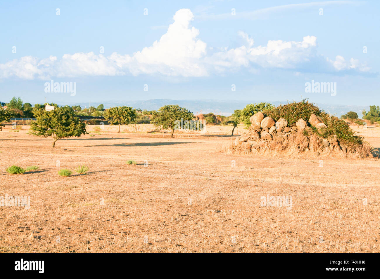 Sardinien-Land wild. Gelbe sardischen Land im Sommer mit den Ruinen von Haustrände und Wolken im Hintergrund Stockfoto