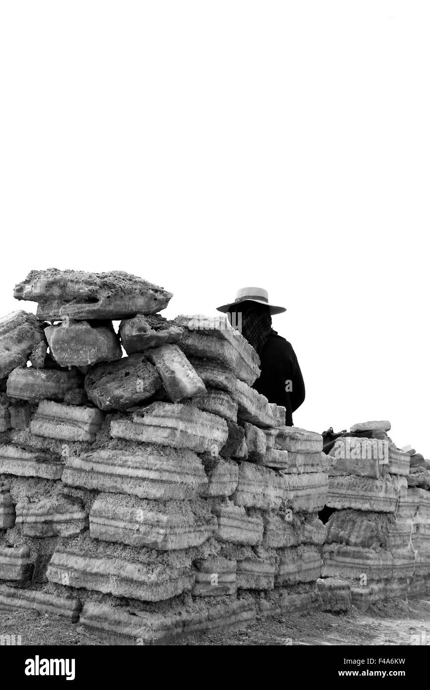 Jujuy - Nord-Argentinien - eine einsame Frau mit typischen Hut von Salinas Grandes, Verkauf von Souvenirs auf Salzziegel sitzen. (B&W) Stockfoto