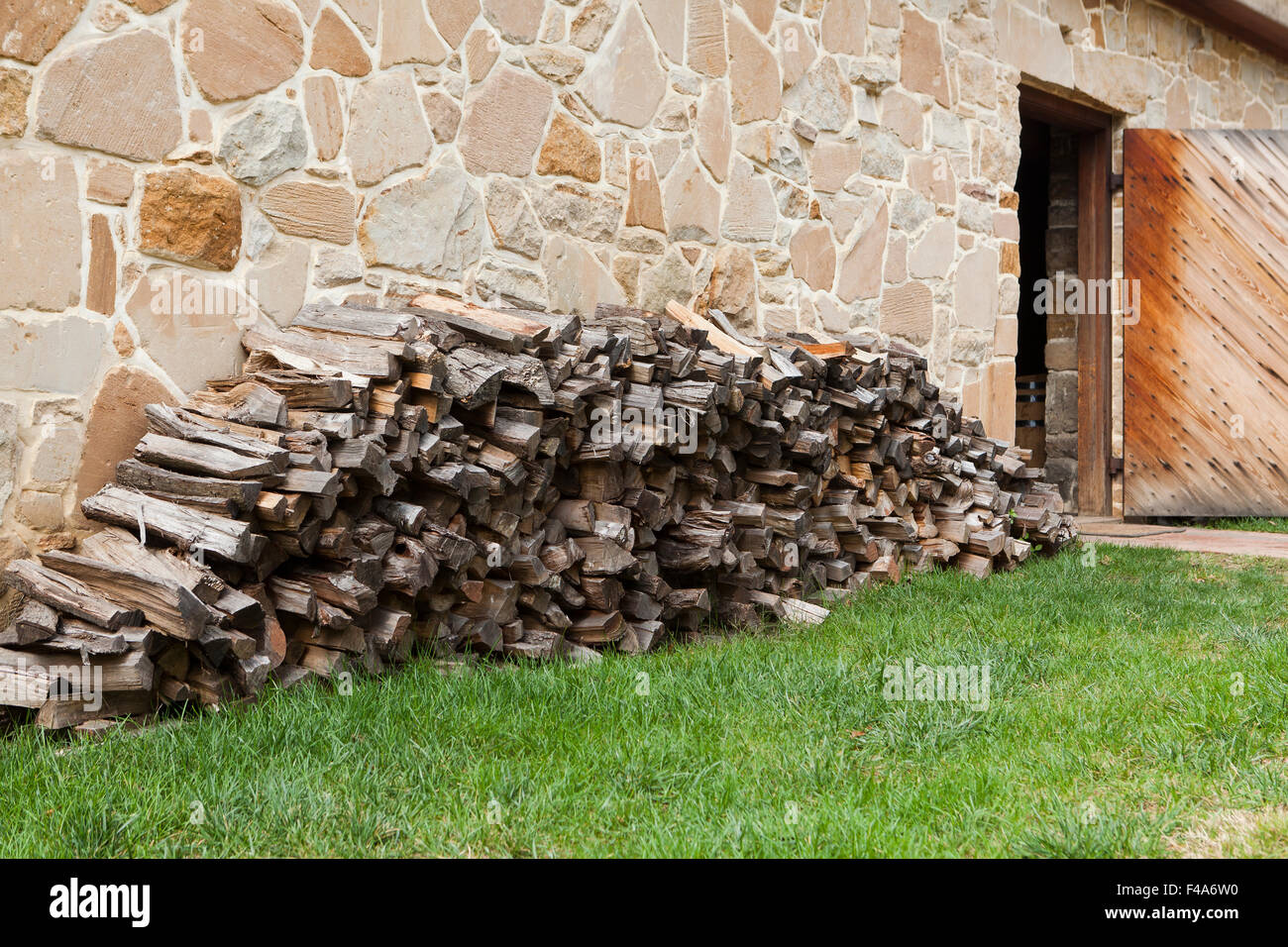 Erfahrene Brennholz gestapelt neben Wand - USA Stockfoto
