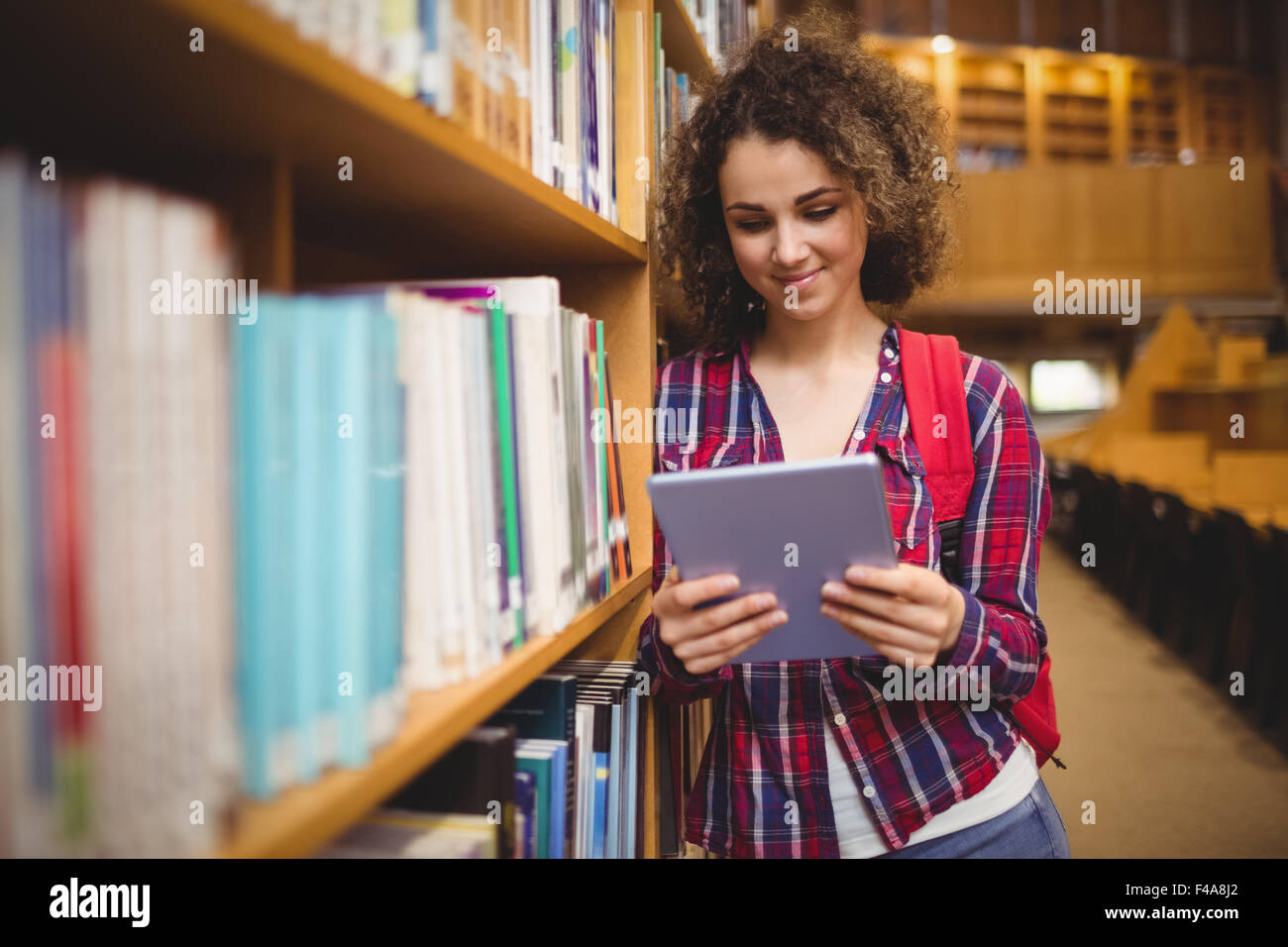 Hübsche Studentin in der Bibliothek mit tablet Stockfoto