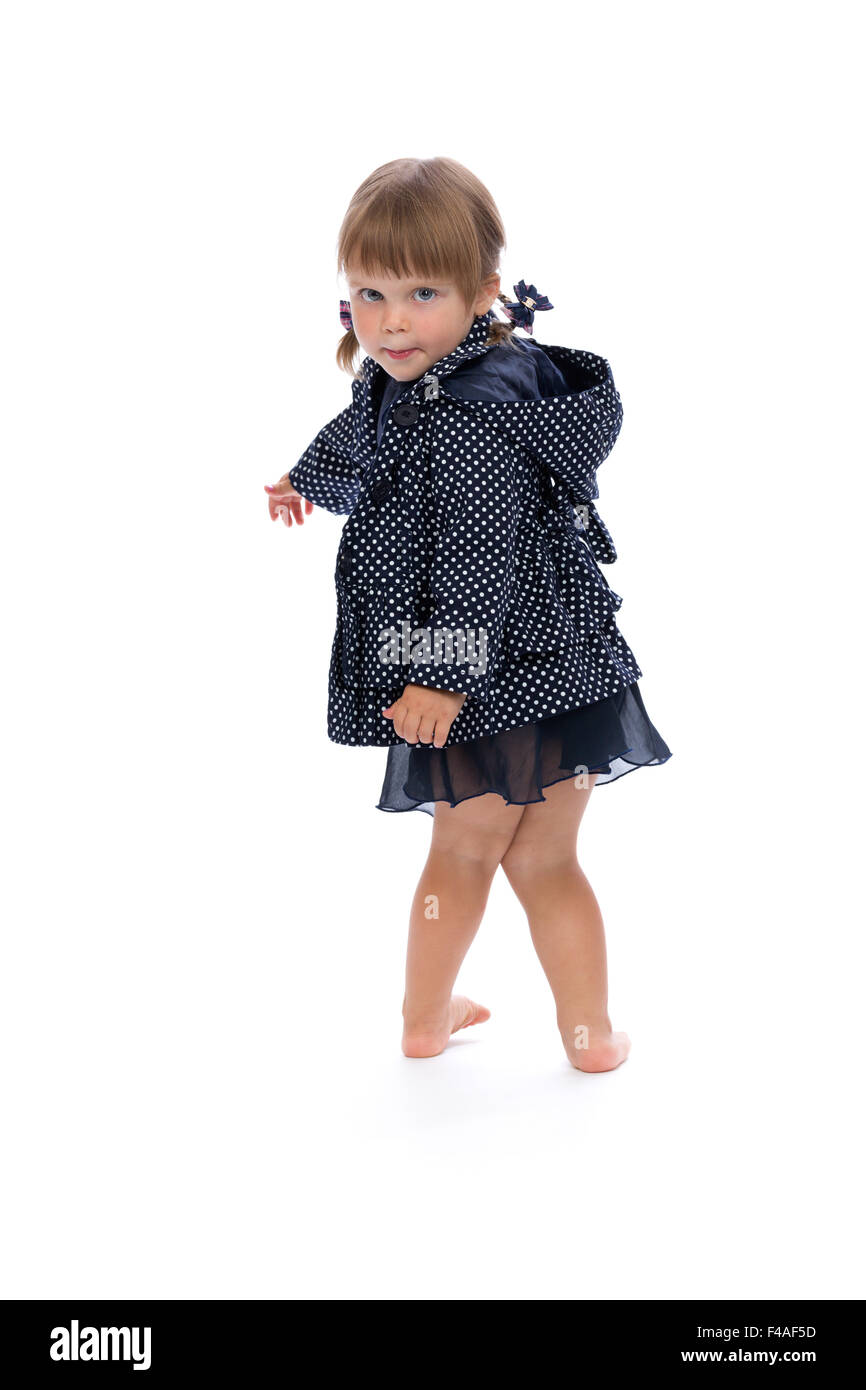 kleines Mädchen in einem gepunkteten Regenmantel isolieren Stockfoto