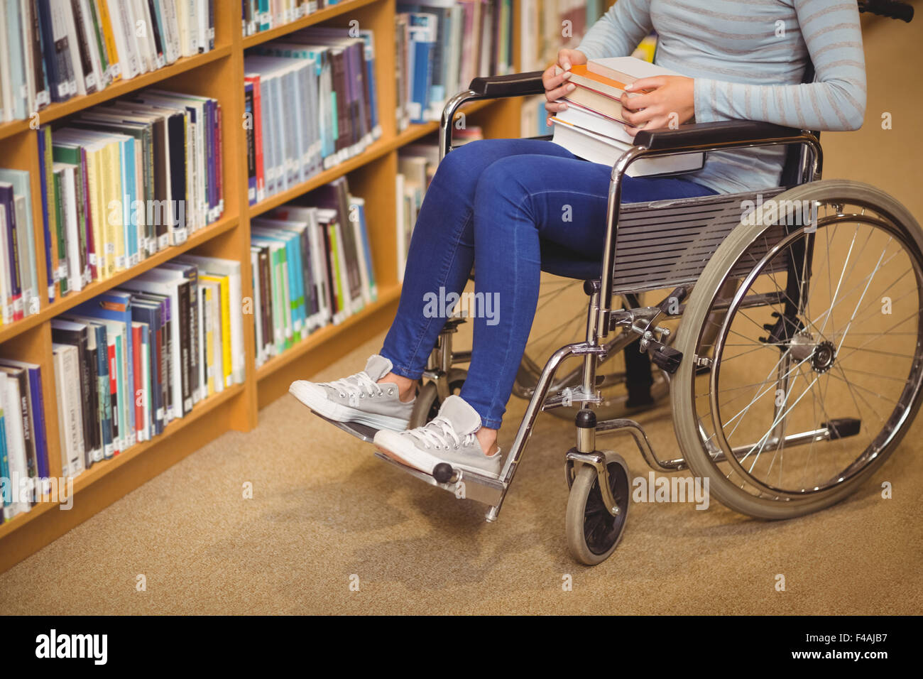 Behinderte Studentin mit Büchern auf Rollstuhl Stockfoto