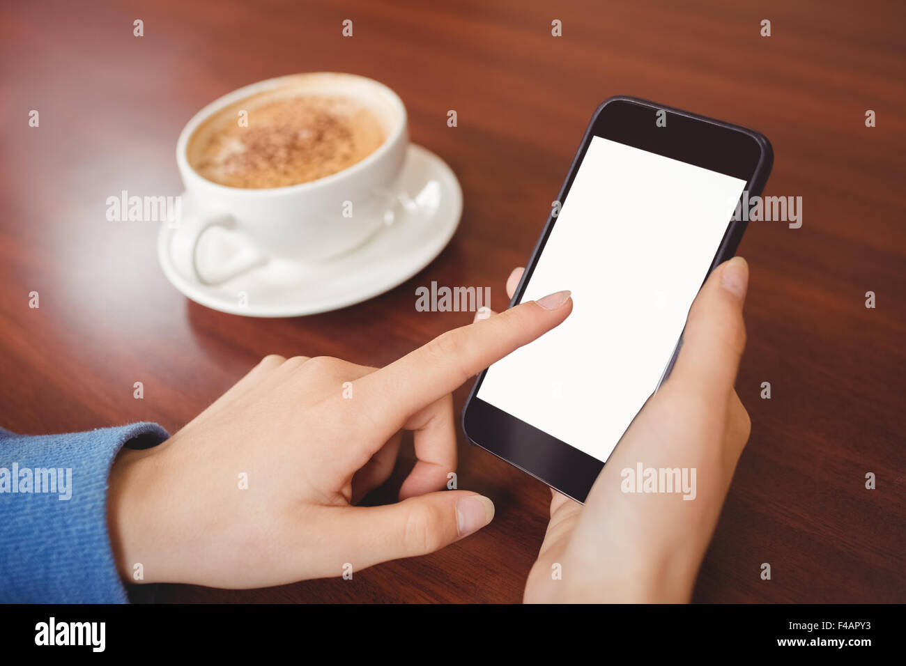Frau mit ihrem Smartphone mit Kaffee Stockfoto