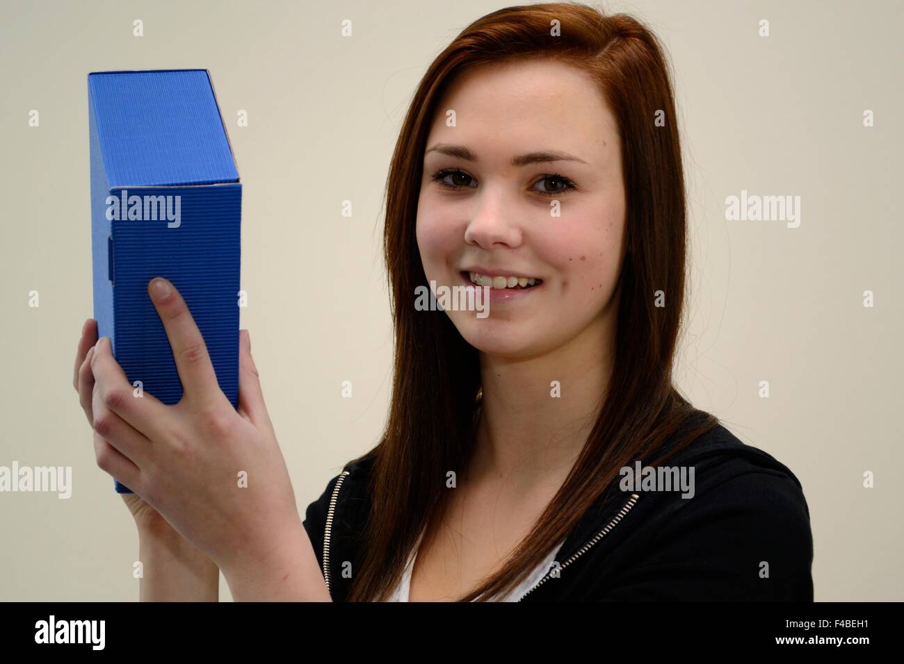 Teenager schüttelt blauen Geschenkbox Stockfoto