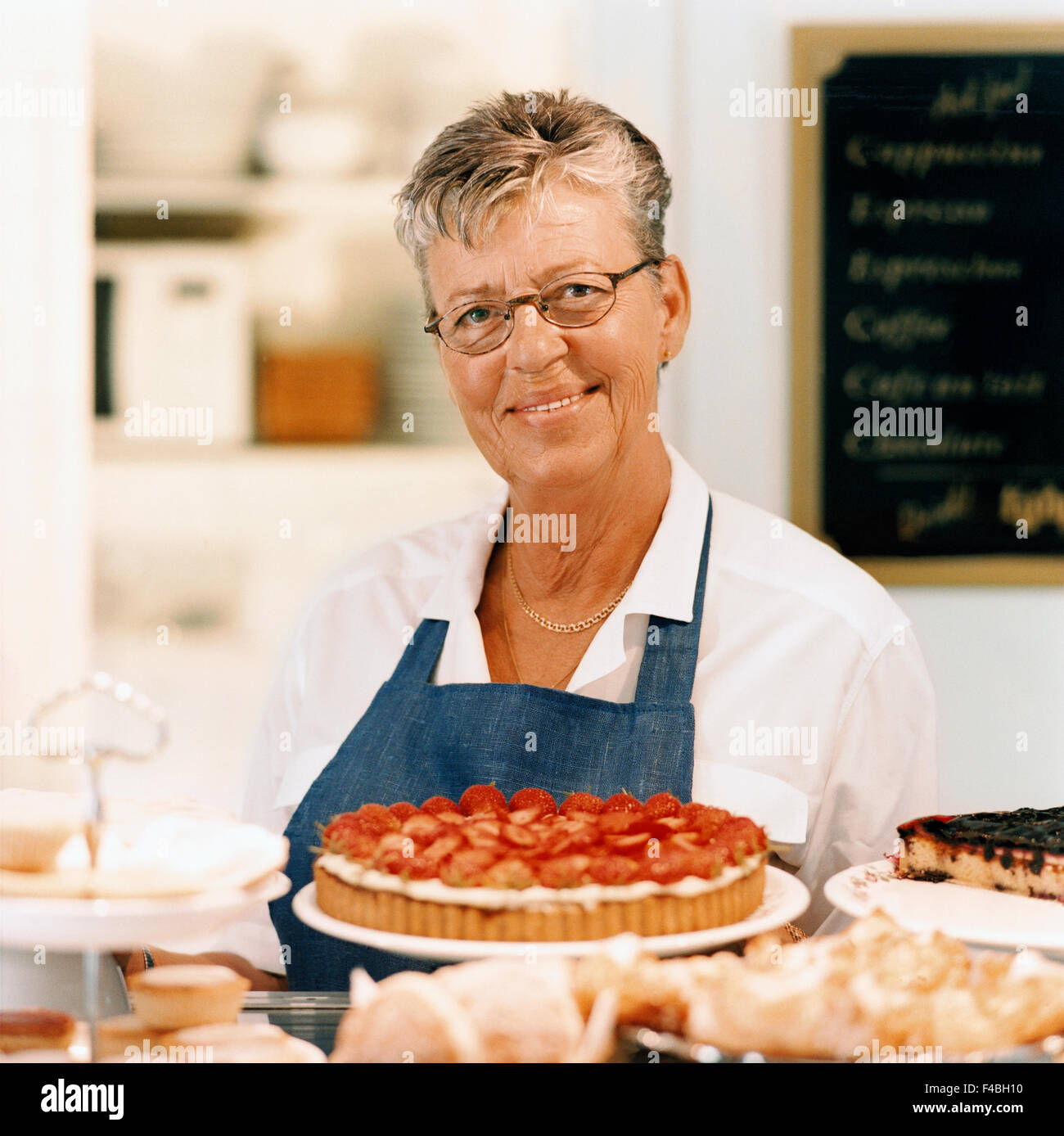 45-49 Jahre Erwachsene nur Bäcker Café Kuchen Katalog 2 Farbe Bild Cookie essen und trinken Vorderansicht glücklich im Haus Innenarchitektur Stockfoto