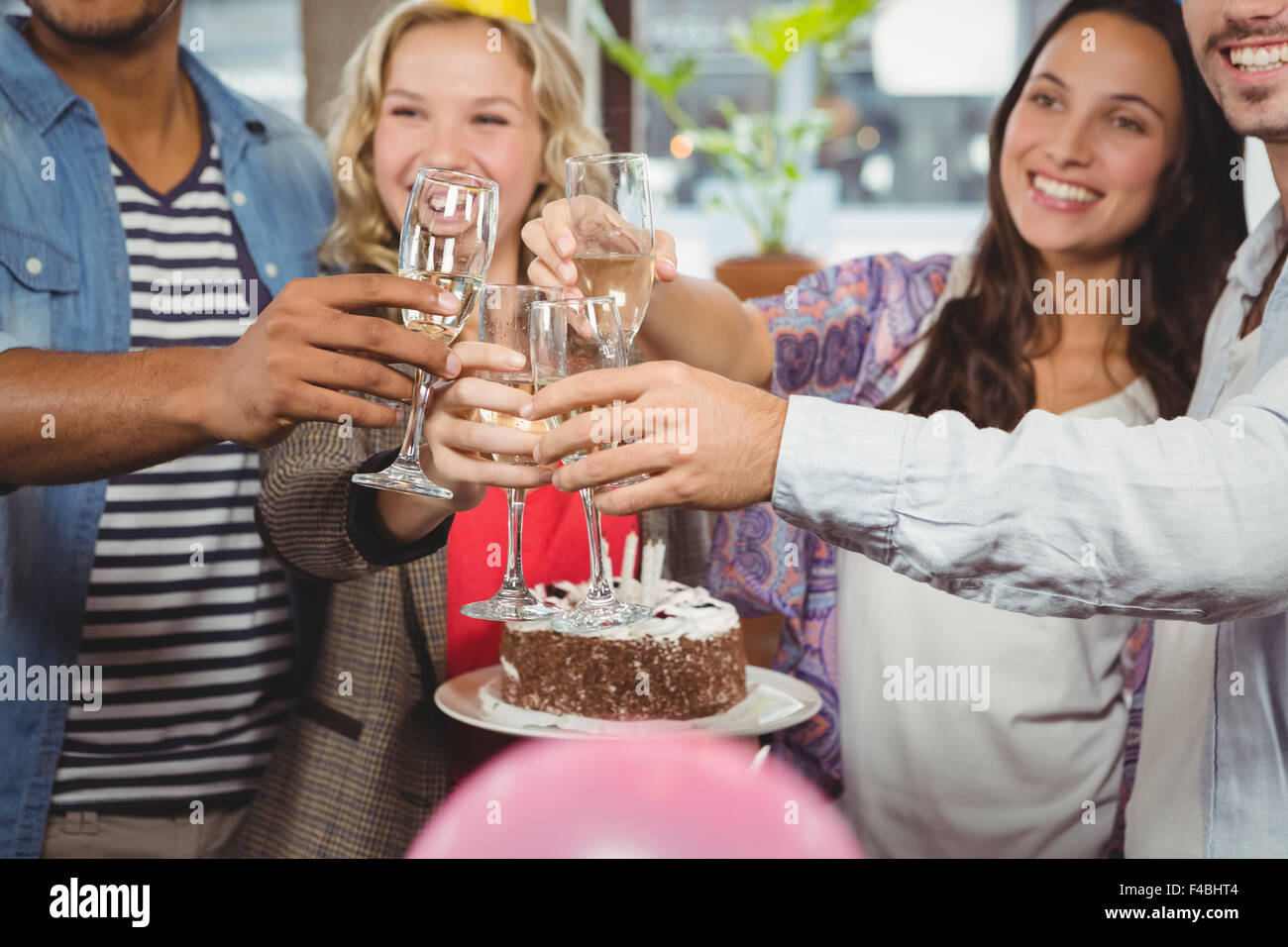 Business-Leute Toasten über Geburtstagstorte Stockfoto