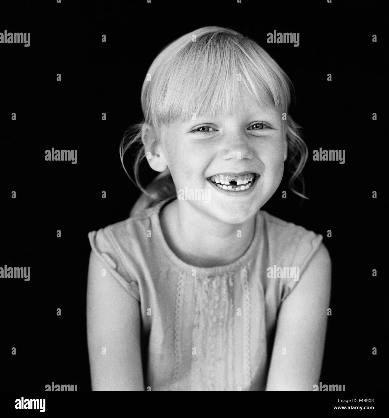 schwarze und weiße blonde Kinder nur Mädchen glücklich drinnen eine Person nur Optimismus Porträt positive lächelnde Zahn zahnlos Stockfoto