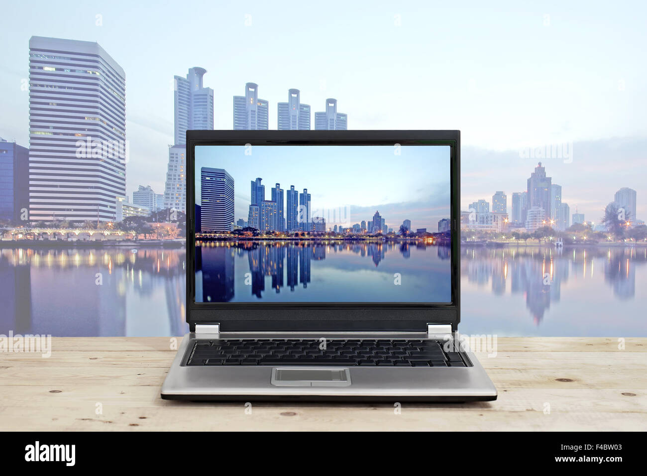 Business Konzeptidee, Laptop auf Holztisch mit hohen Gebäude Hintergrund Stadtbild Stockfoto