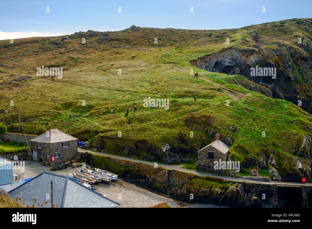 Wanderer erklimmen der South West Coast Path im Mullion Cove, Pfosten, Halbinsel Lizard, Cornwall, England, UK Stockfoto