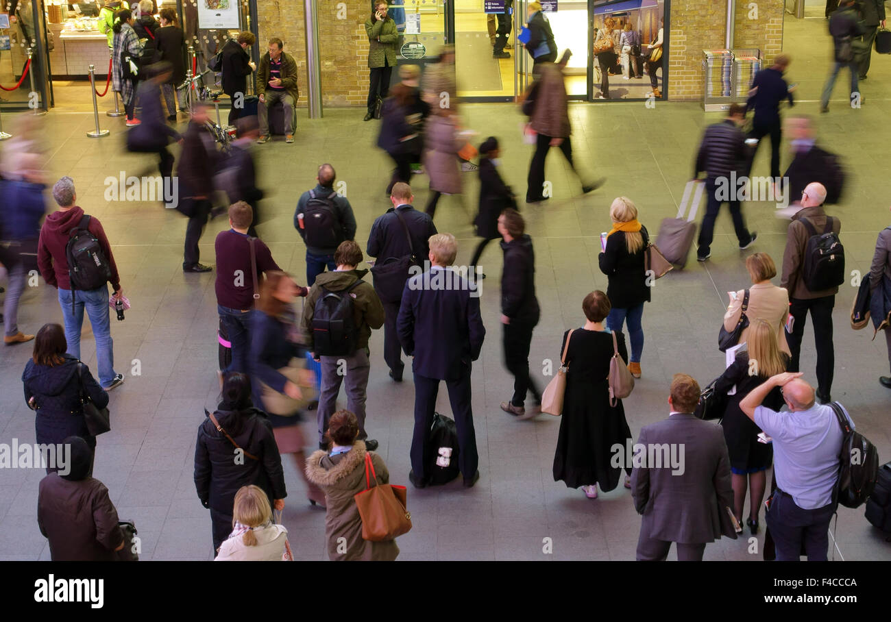 Passagiere sehen Anzeigentafel in Kings Cross Bahnhof, London Stockfoto