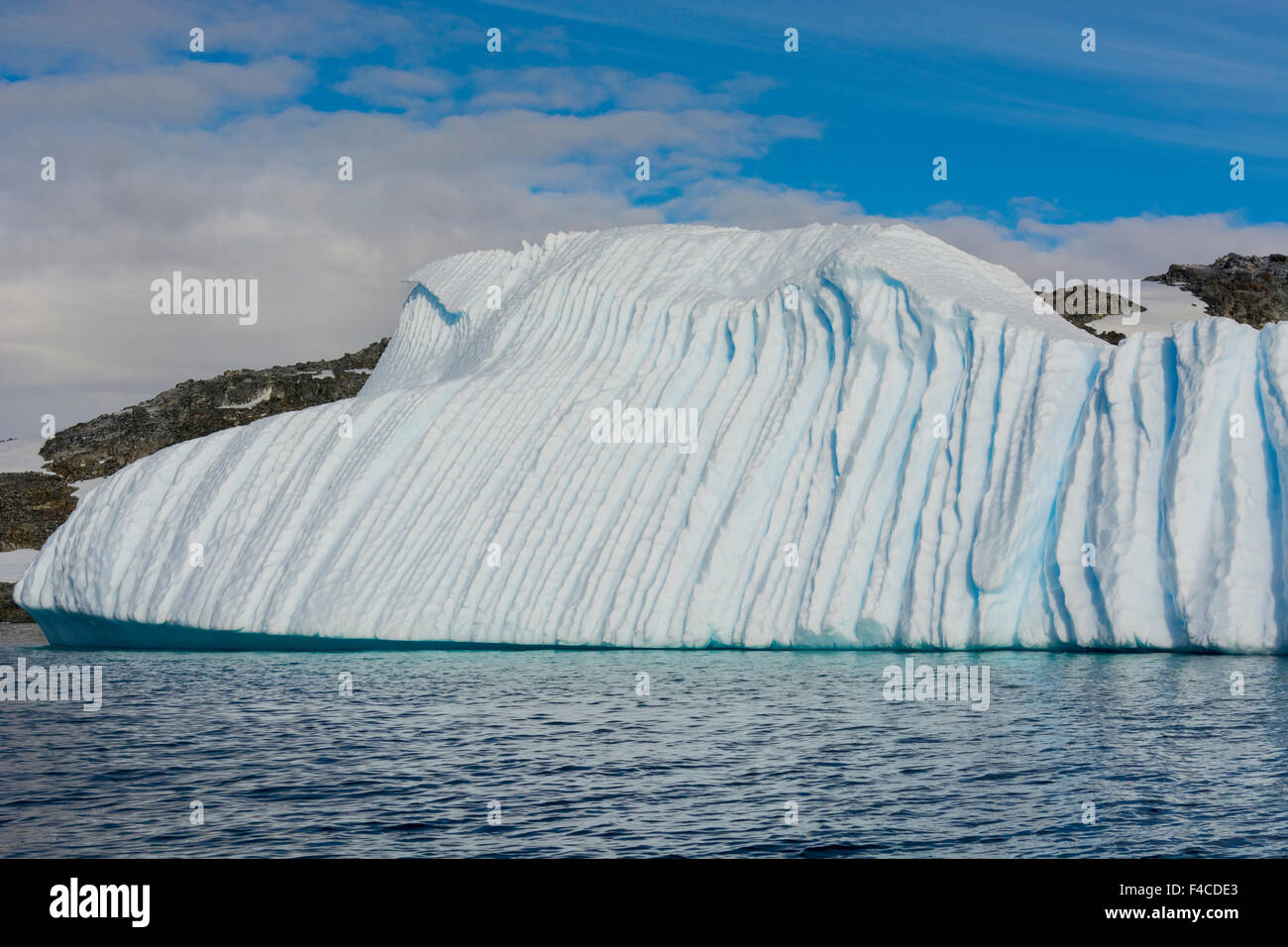 Antarktis. Gerlache Strait. Tief gerillt Eisberg zeigt, wo es unter Wasser geschmolzen. Stockfoto