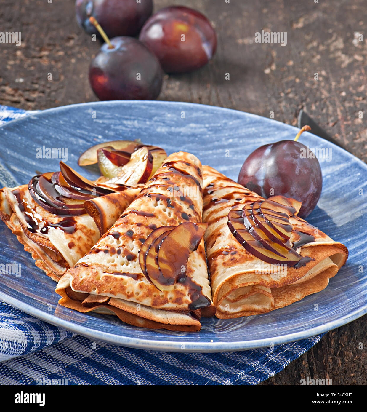 Palatschinken mit Schokolade Sirup und Pflaumen Stockfoto