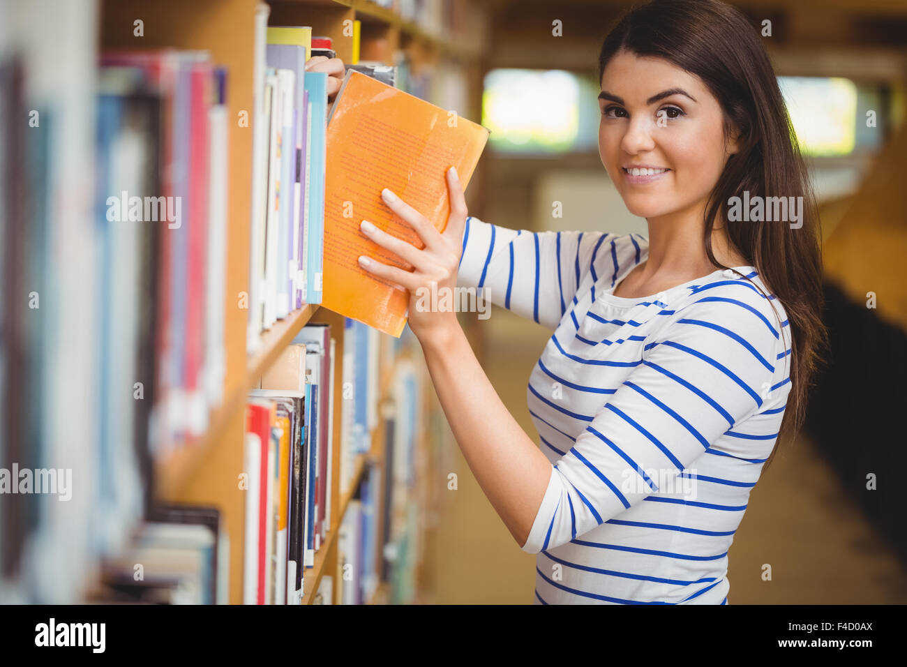 Porträt von Studentin Buch auswählen Stockfoto