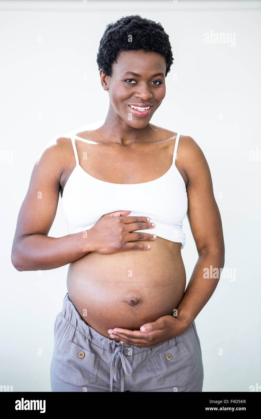 Glückliche Frau reibt ihren schwangeren Bauch Stockfoto