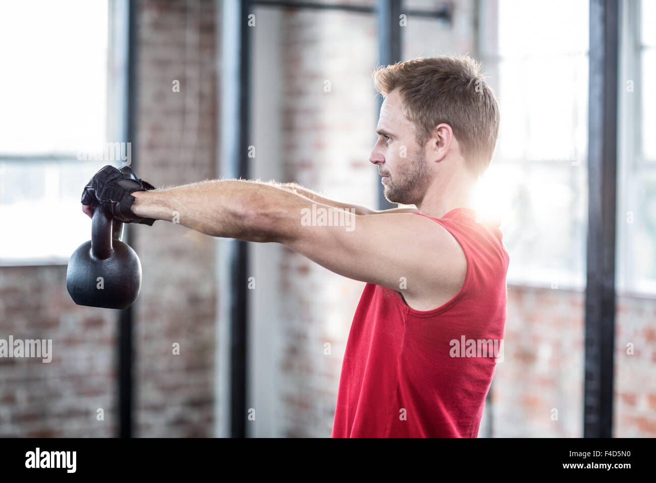 Muskulöser konzentriert Mann heben kettlebells Stockfoto