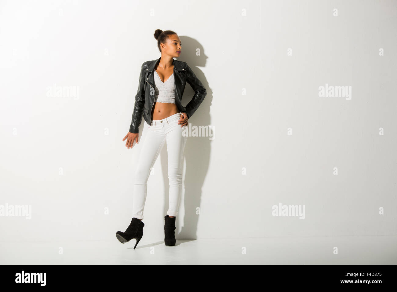 Teenager Mode-Modell auf eine weiße Wand, Blick in die Kamera rechts gelehnt. Stockfoto