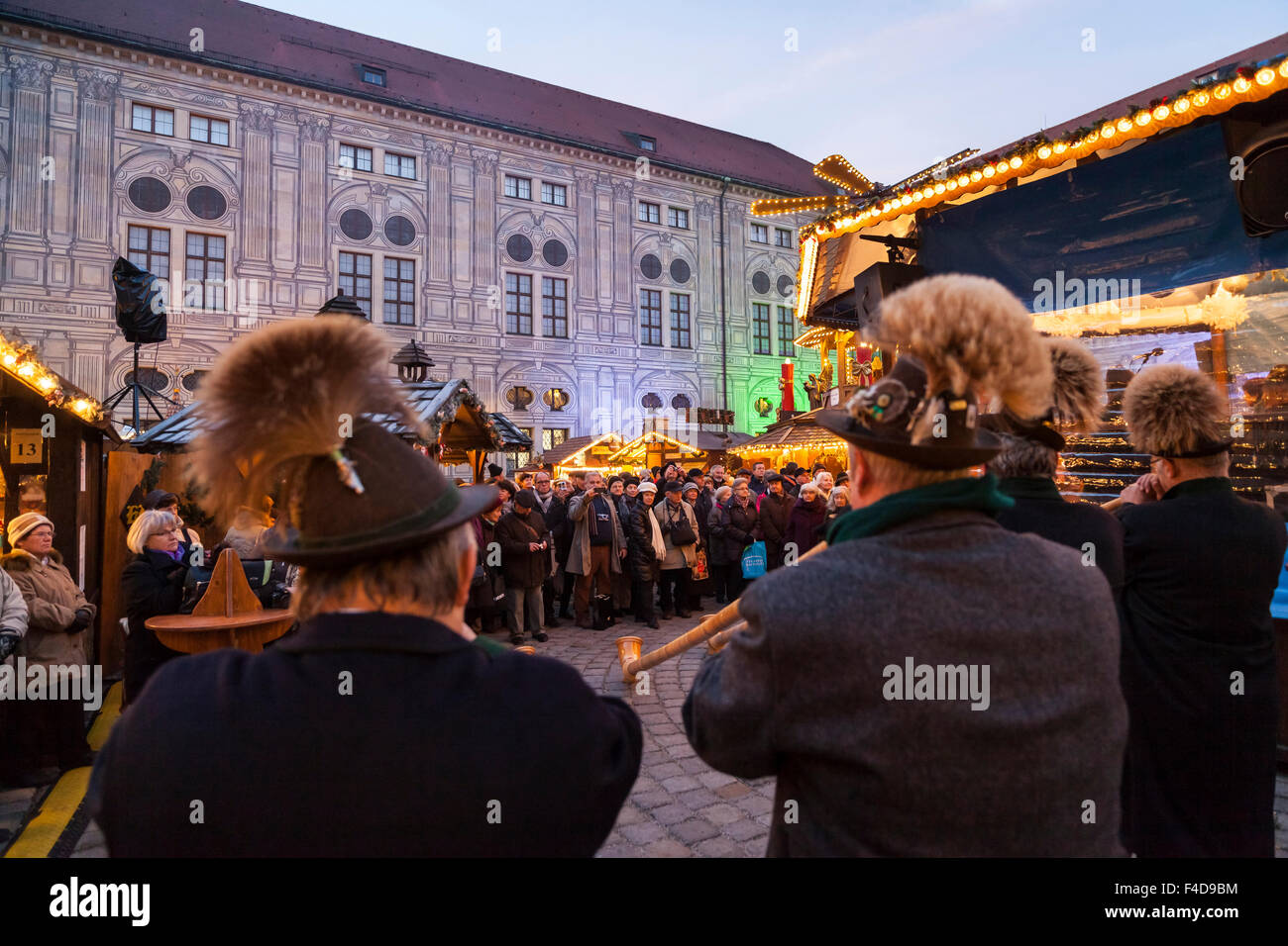 Das alpine Weihnachtsdorf im Kaiserhof der Residenz, das Schloss der Bayerischen Könige. Konzert mit Alphorn (Alphorn). München, Bayern, Deutschland. Stockfoto