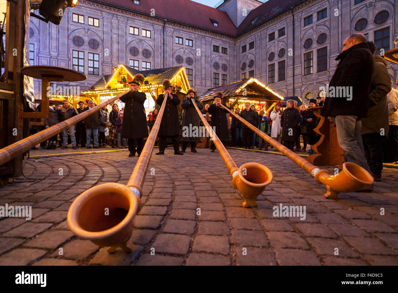 Das alpine Weihnachtsdorf im Kaiserhof der Residenz, das Schloss der Bayerischen Könige. Konzert mit Alphorn (Alphorn). München, Bayern, Deutschland. Stockfoto