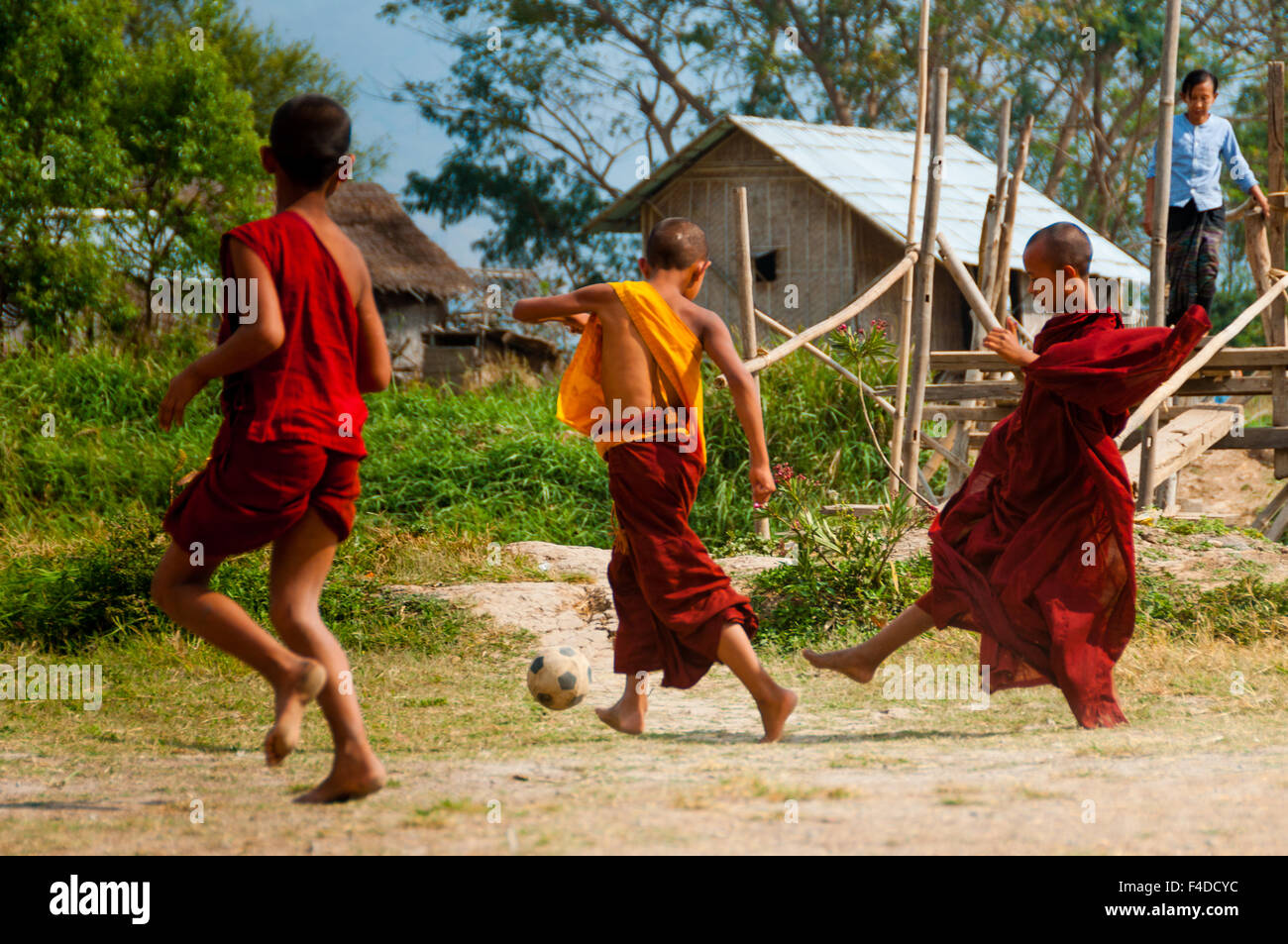 Drei Mönche im roten Gewand Fußball spielen Stockfoto