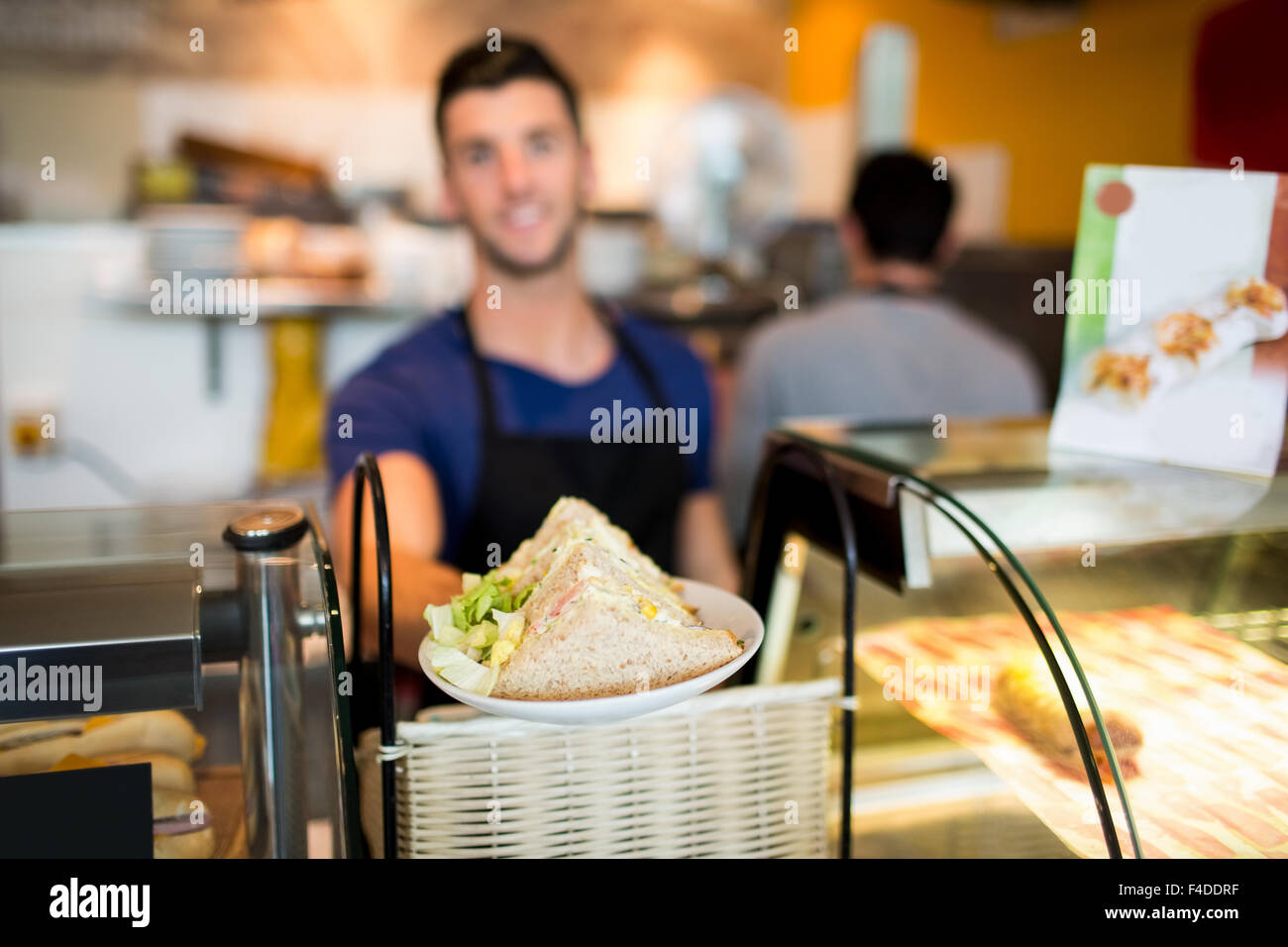 Hübscher Kellner bieten Mittagessen an Kamera Stockfoto