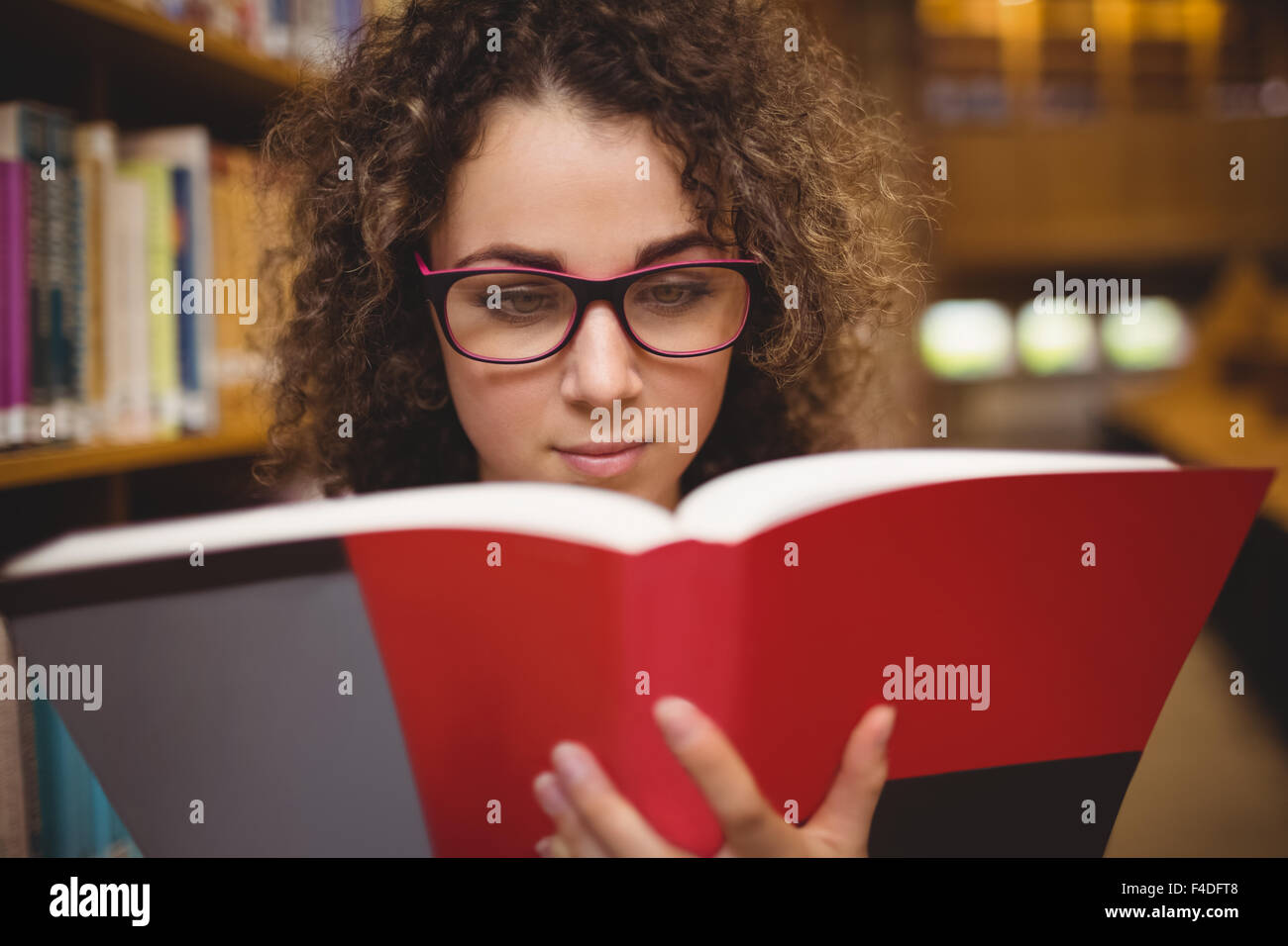 Hübsche Studentin in der Bibliothek Buch Stockfoto