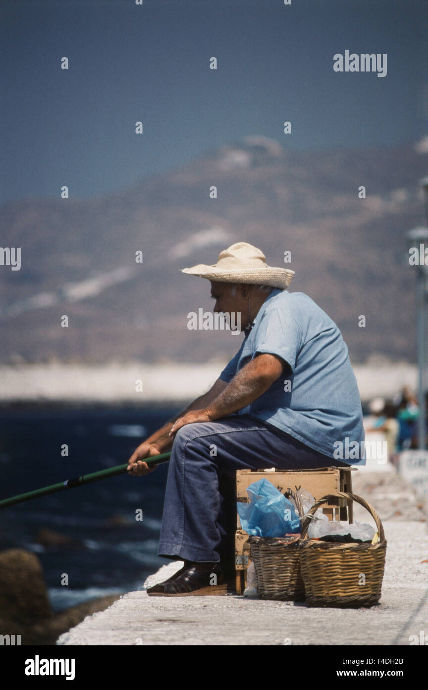 Griechenland, Mykonos, Mann am Pier Angeln (großformatige Größen erhältlich) Stockfoto